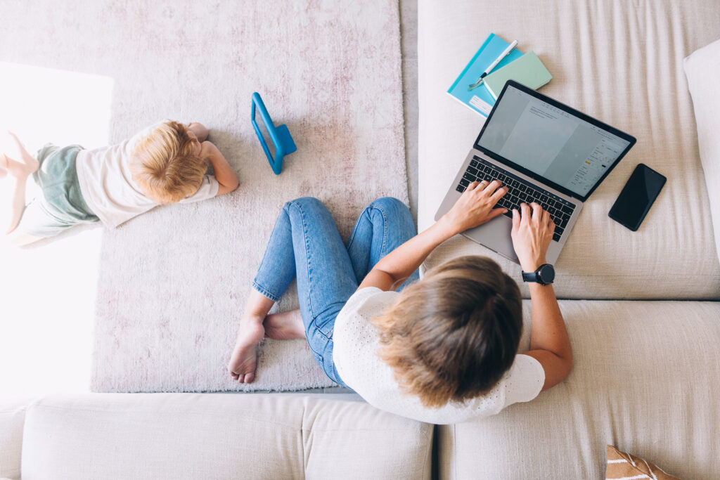 Woman getting on couch with computer while scheduling chiropractic adjustment with Greenbrier Family Chiropractic