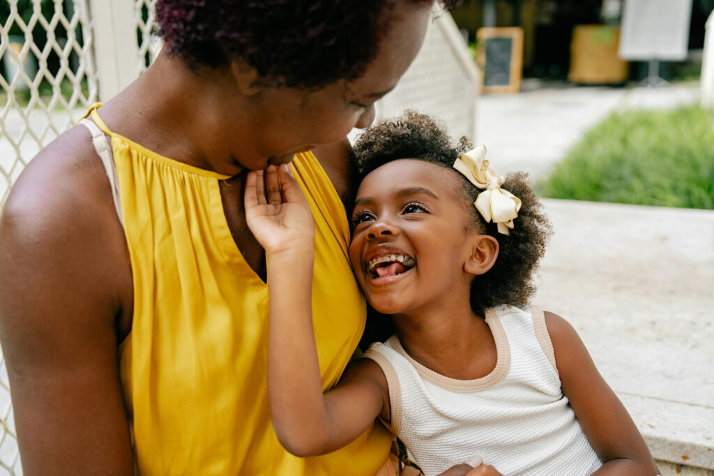 Mom and daughter sitting outside and smiling after family chiropractic appointment in Chesapeake, VA.